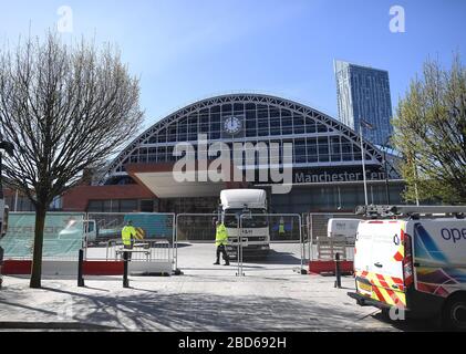 Bauarbeiter des neuen provisorischen NHS Nightingale Hospital North West, das im Manchester Central Conference Center in Manchester gebaut wird, während Großbritannien weiterhin in Sperrungen arbeitet, um die Ausbreitung des Coronavirus einzudämmen. Stockfoto