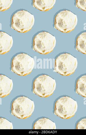 Nahtloses Muster aus Kokosnuss Cupcake mit weißer Schlagsahne Vanille Icing Cream auf pastellblauem Hintergrund. Das Konzept eines Urlaubs, Party, Süßigkeiten Stockfoto