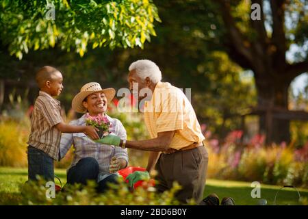 Großvater verbünd sich mit seiner Tochter und seinem Enkel im Garten. Stockfoto