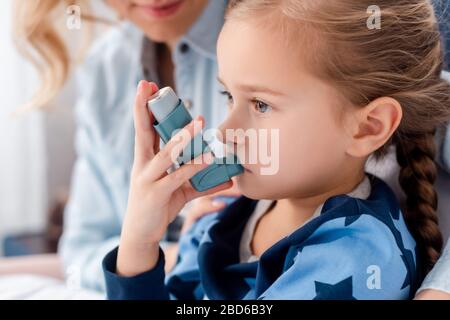 Selektive Fokussierung kranker Kinder mit Inhalator in der Nähe pflegender Mutter zu Hause Stockfoto