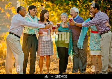 Lächelnd Gruppe von Freunden feiern mit Getränken in einem Hinterhof. Stockfoto