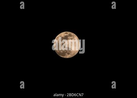 Guwahati, Assam, Indien. April 2020. Der Mond steigt in den Himmel über Guwahati. Menschen, die aufgrund des von Coronavirus ausgelösten Lockdowns in ihren Häusern eingegrenzt sind, können Supermoon am Mittwoch, 8. April 2020 beobachten. Credit: David Talukdar/ZUMA Wire/Alamy Live News Stockfoto