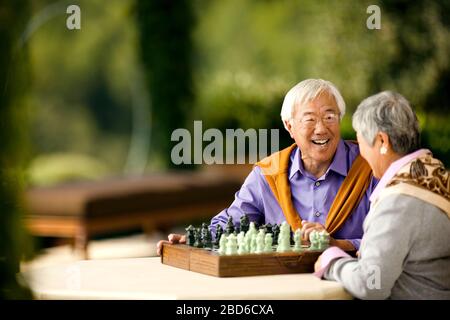 Gerne älteres Paar spielen eine Partie Schach. Stockfoto