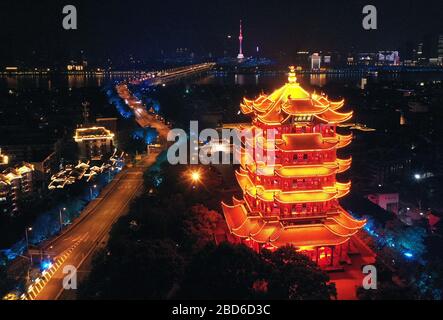 Wuhan, China. April 2020. Das Luftbild vom 7. April 2020 zeigt den beleuchteten gelben Kranturm oder Huanghelou, ein Wahrzeichen der Stadt Wuhan, der zentralen chinesischen Provinz Hubei. Wuhan wird voraussichtlich ab Mittwoch die Beschränkungen für ausgehende Reisen aufheben. Kredit: Li He/Xinhua/Alamy Live News Stockfoto