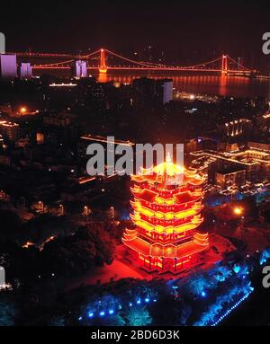 Wuhan, China. April 2020. Das Luftbild vom 7. April 2020 zeigt den beleuchteten gelben Kranturm oder Huanghelou, ein Wahrzeichen der Stadt Wuhan, der zentralen chinesischen Provinz Hubei. Wuhan wird voraussichtlich ab Mittwoch die Beschränkungen für ausgehende Reisen aufheben. Kredit: Li He/Xinhua/Alamy Live News Stockfoto