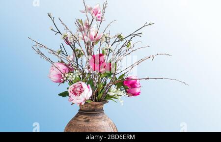 Moderner künstlicher Frühlingsblumenstrauß in Holzvase. Stockfoto