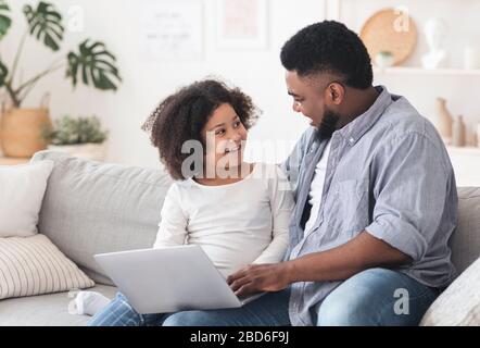 Fürsorglich Black Father Unterrichtet Kleine Tochter Wie Man Laptop Benutzt Stockfoto