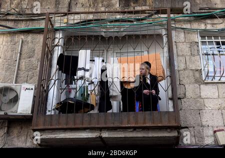 Jerusalem, Israel. April 2020. Ein ultraorthodoxen jüdischer Junge sitzt am Dienstag, 7. März, im Mea Shearim, Jerusalem auf einem Balkon. Der israelische Premierminister Benjamin kündigte strenge Reisebeschränkungen und eine Ausgangssperre für den Passah-Urlaub an, um die Ausbreitung des Coronavirus zu stoppen. Foto von Debbie Hill/UPI Credit: UPI/Alamy Live News Stockfoto
