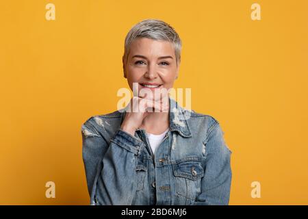 Porträt Der Selbstbewussten Reifen Dame, Die Chin Berührt Und Camera Lächelt Stockfoto