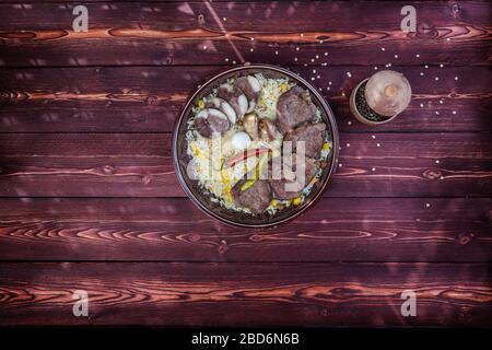 Das Konzept der orientalischen Küche. Nationaler usbekischer Pilaf mit Fleisch. Draufsicht, Kopierbereich. Stockfoto