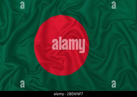Flagge des Landes Bangladesch auf welligem Seidentextiliengewebe im Hintergrund. Stockfoto