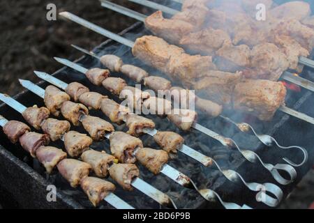 Auf dem Grill gegrillte Spieße mit Schalen Stockfoto