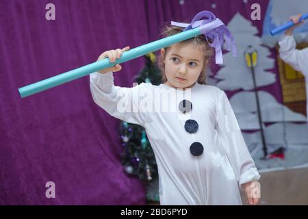 Die Kinder sind als Schneemänner verkleidet. Kindergartenteilnehmer nehmen an einer Neujahrsveranstaltung Teil. Niedliche Jungen in festlichen Kostümen des Weihnachtsmanns Stockfoto