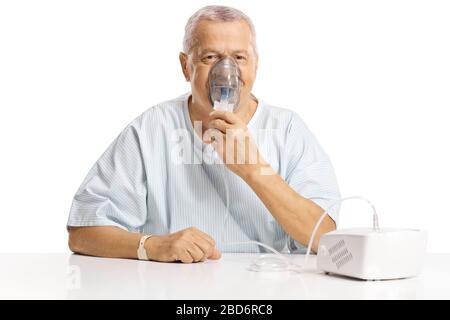 Ältere männliche Patienten mit einem Inhalator, der auf weißem Hintergrund isoliert ist Stockfoto