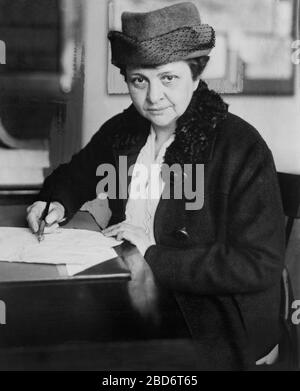 Frances Perkins (1880-1965), amerikanische Soziologin und Worters-Rights-Advocate, war 1933-1945 als US-amerikanische Arbeitsministerin tätig, erste Frau, die in das US-Kabinett berufen wurde, halblanges Portrait Signing Document, Keystone View Company, 1918 Stockfoto