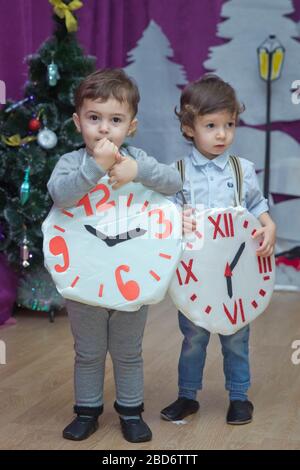 Die Kinder . Kindergartenteilnehmer nehmen an einer Neujahrsveranstaltung Teil. Niedliche Jungs in festlichen Kostümen des Anzugs. Fröhliches Kind mit großem Festhalten Stockfoto