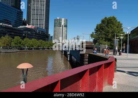 Melbourne Australia - 10. März 2019; Red Rail führt zur Sandridge Fußgängerbrücke mit Menschen und Zierskulpturen aus Edelstahl über Yarr Stockfoto