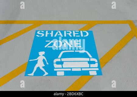 Auto und Leute teilten sich das Zonenschild auf dem Boden Warnung. Stockfoto