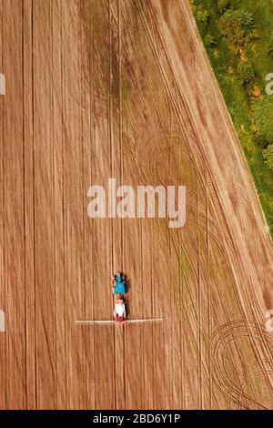 Traktor sprühen Ernten in Feld, Luftaufnahme von Drone pov Stockfoto