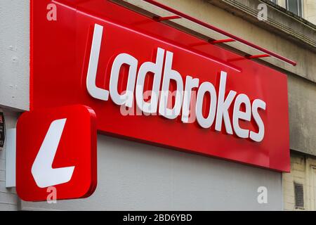 Ladbrokes Wettbüro Logo, montiert über einem Wettgeschäft, Kilmarnock, Ayrshire, Großbritannien Stockfoto