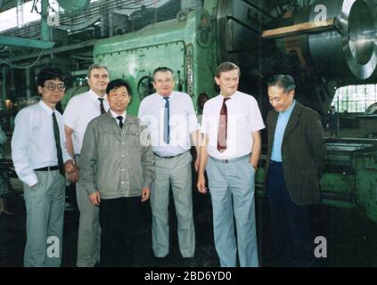 CHINA - 1989: Retro-Foto zeigt eine Gruppe europäischer Geschäftsleute und chinesischer Führer in der chinesischen Fabrik. Maschinenbauwerk. Stockfoto