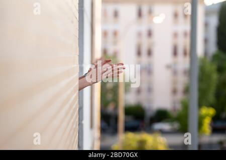 Frau klatscht im Fenster und unterstützt Menschen, die gegen das Coronavirus kämpfen Stockfoto