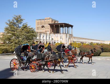 Pferdekutschen am Meidan-e Emam, Naqsh-e Jahan, Imam-Platz, Ali Qapu Palast im Hintergrund, UNESCO-Weltkulturerbe, Esfahan, Isfahan Stockfoto