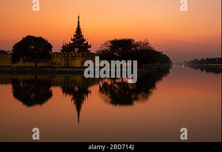 Sonnenuntergang mit buntem Himmel von einem der vier Wachtürme des Palastkomplexes, Mandalay, Myanmar Stockfoto