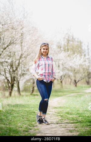 Schönes Mädchen in blühenden Bäumen im Frühjahr. Helle Sonne und Natur Stockfoto