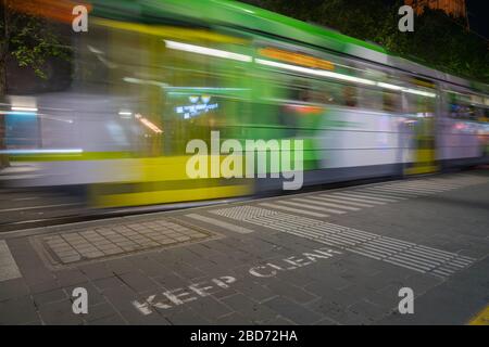 Melbourne, Australien - 9. März 2020; verschwommenes Bild der Straßenbahn der Stadt, die vorbei whizing, halten Sie klares Zeichen auf dem Straßenbelag Stockfoto