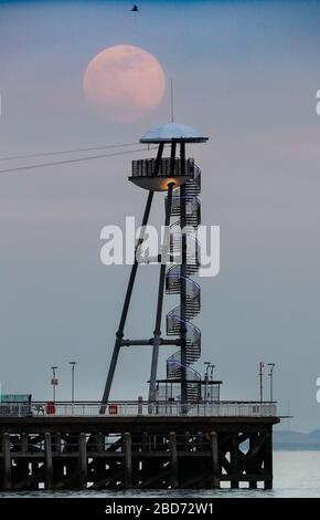 Bournemouth, Großbritannien. April 2020. Der Super Pink Moon erhebt sich über dem Bournemouth Pier in Dorset. Gutschrift: Richard Crease/Alamy Live News Stockfoto