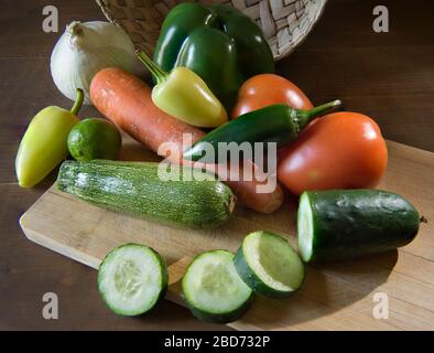 Gemüse auf einem Schneidebrett in einer mexikanischen Küche Draufsicht mit einem Korb im Hintergrund und Rand Licht oder Hintergrundbeleuchtung Stockfoto