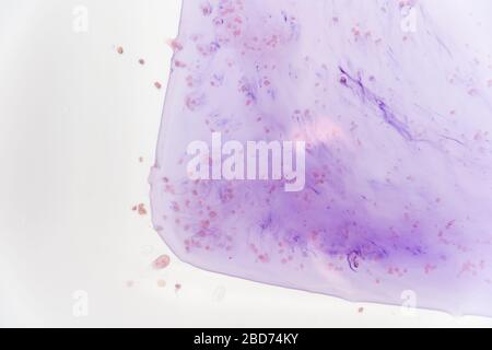 Blaue Flecken aus dem Farbstoff in der weißen Wanne lösen sich in Wasser Stockfoto