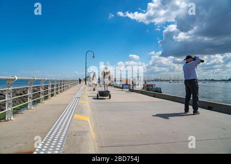 Melbourne Australia - 11. März 2020; St Kilda Pier mit Touristen und Menschen, die am Ende des langen Piers aus dem Kiosk spazieren und zurückkehren. Stockfoto