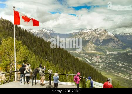 BANFF, AB, Kanada - Juni 2018: Besucher auf dem Aussichtspunkt auf dem Gipfel des Sulphur Mountain im Banff. Stockfoto