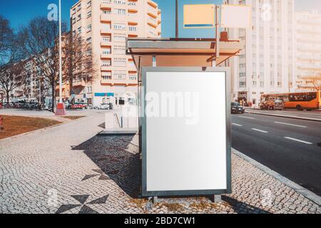 Eine Bushaltestelle in der Nähe der Straße mit einem verspottet von einem leeren Werbeplakat darauf; eine Vorlage einer leeren Informationstafel an der Haltestelle des öffentlichen Verkehrs; m Stockfoto