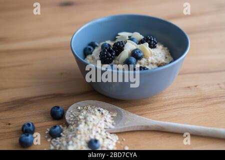 Porridge in Schüssel mit Brombeeren und Blaubeeren, gesundes Frühstück, Deutschland Stockfoto