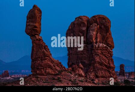 Balanced Rock im Arches National Park in der Dämmerung mit den La Sal Bergen im Hintergrund, Utah, USA. Stockfoto