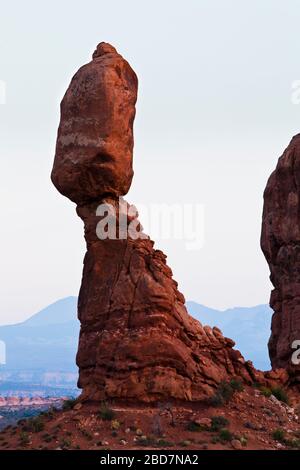 Balanced Rock im Arches National Park in der Dämmerung mit den La Sal Bergen im Hintergrund, Utah, USA. Stockfoto