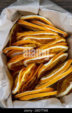 Fruchtchips aus orangefarbenen Scheiben in einer Papiertüte. Obere Ansichten, Nahaufnahme Stockfoto