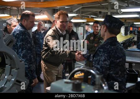 BREMERTON, Washington (Feb. 15, 2018) unter Marinesekretär Thomas B. Modly schüttelt mit einem Sailor an Bord der USS John C. Stennis (CVN 74) die Hände. Modly war an Bord für eine Tour durch das Schiff und mit Sailors und Command Leadership zu sprechen. John C. Stennis führt routinemäßige Schulungen durch, während er sich weiterhin auf die nächste planmäßige Bereitstellung vorbereitet. Kredit: Storms Media Group/Alamy Live News Stockfoto