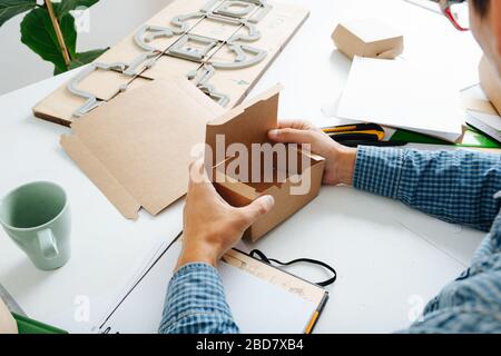 Box Maker in Brille und kariertem Hemd, mit Box in den Händen Stockfoto