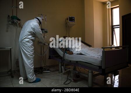 Douris, Libanon, 7. April 2020. Ein Arzt neigt zu einem COVID19-Patienten auf der COVID-Station A. des dar Al Amal University Hospital. Einer von zwei ICU-Patienten und fünf Patienten, die insgesamt mit dem Virus infiziert sind, wird intubiert und mit einem Beatmungsgerät verwendet. Elizabeth Fitt Credit: Elizabeth Fitt/Alamy Live News Stockfoto