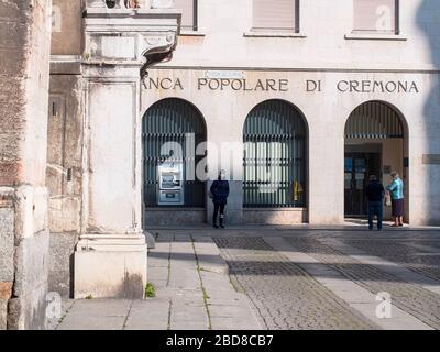 Unidentifizierte wenige Menschen in leeren Straßen im Jahr 2020 sperren sich und Ausbruch in Cremona, Italien unter Quarantäne Stockfoto