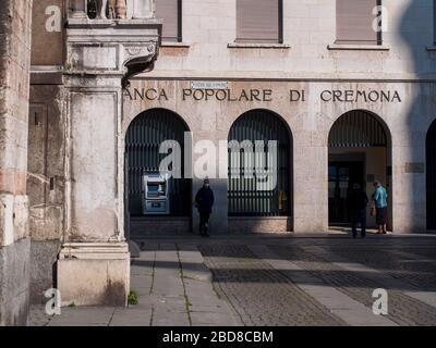 Unidentifizierte wenige Menschen in leeren Straßen im Jahr 2020 sperren sich und Ausbruch in Cremona, Italien unter Quarantäne Stockfoto