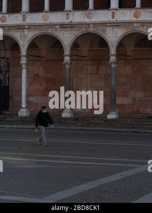 Unidentifizierte wenige Menschen in leeren Straßen im Jahr 2020 sperren sich und Ausbruch in Cremona, Italien unter Quarantäne Stockfoto