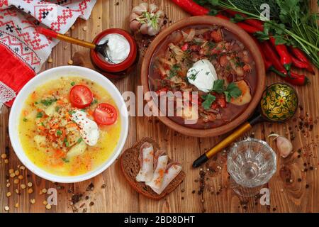 Borsch mit Sauerrahm, Schmalz und Wodka auf einem Holztisch Stockfoto