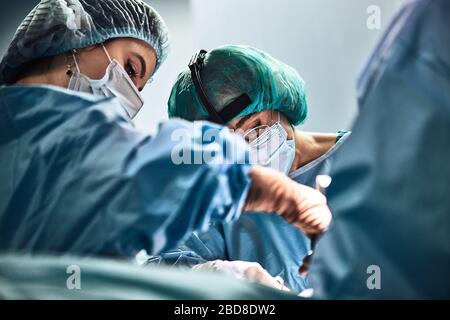 Ein Chirurgen-Team in Uniform führt eine Operation an einem Patienten in der Klinik des Zentrums. Stockfoto