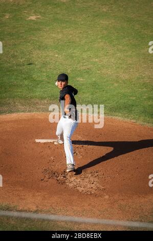 Teen Baseball Krug in schwarz-weiß Uniform auf dem Hügel Stockfoto