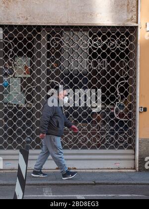 Unidentifizierte wenige Menschen in leeren Straßen im Jahr 2020 sperren sich und Ausbruch in Cremona, Italien unter Quarantäne Stockfoto